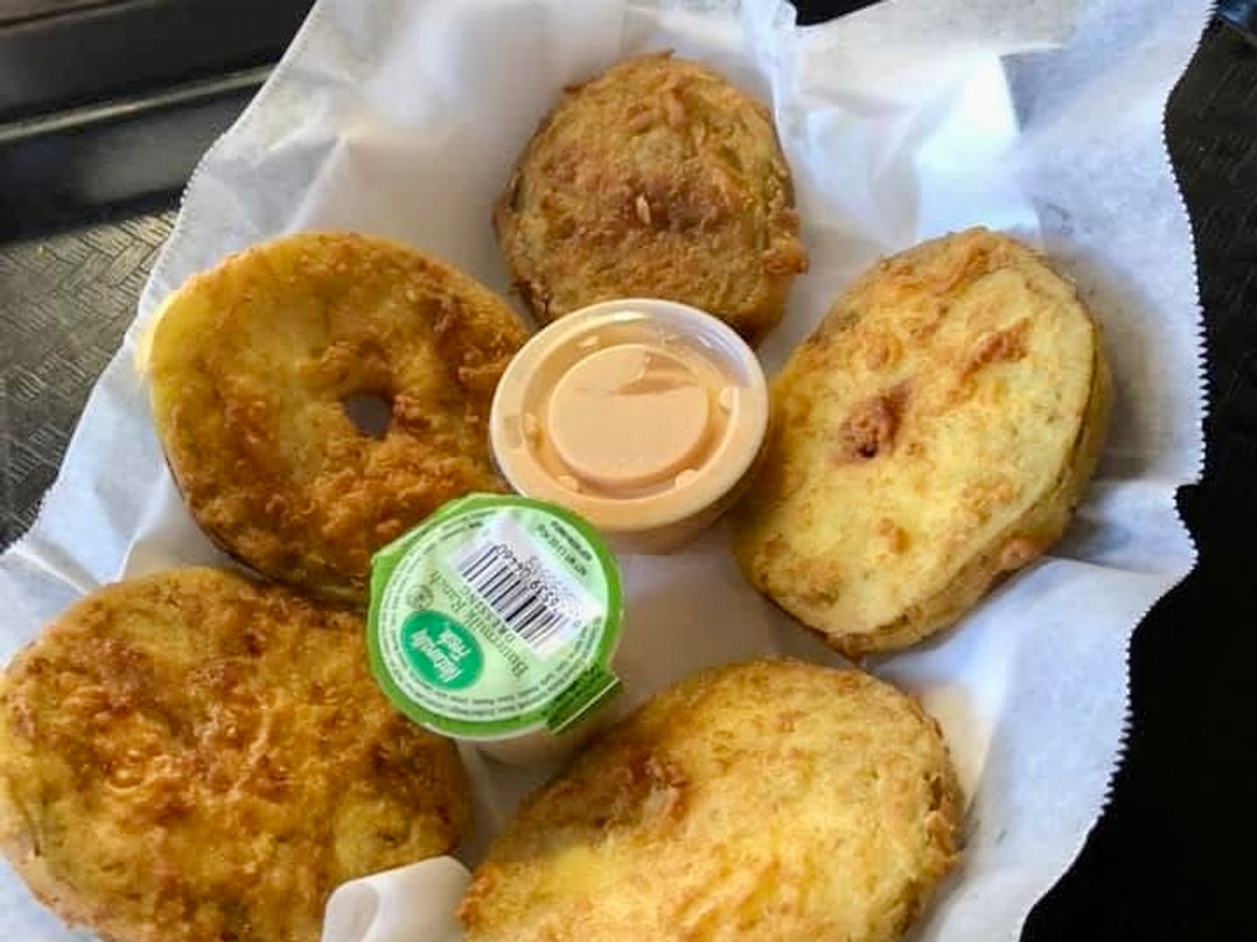 Fried green tomato slices served with a cup of dipping sauce