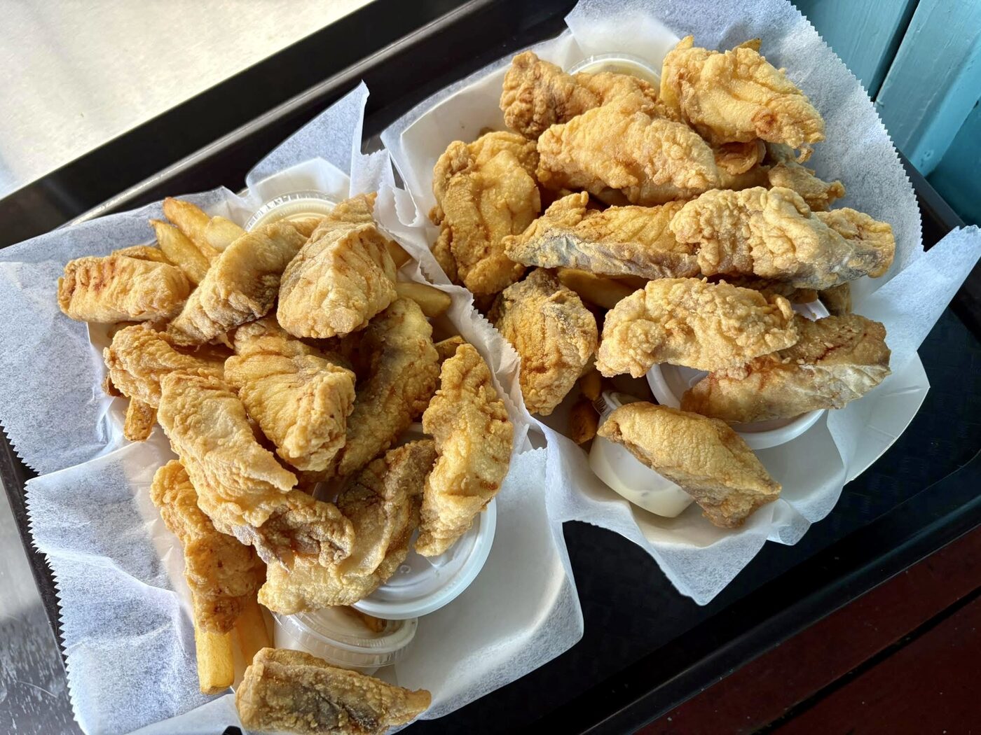 A paper-lined basket of freshly fried fish fillets at The Fish House